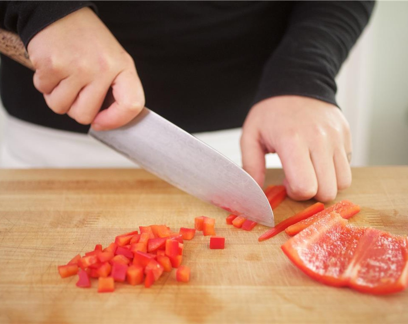 Schritt 2 Stiel, Kerne und Mark der Peperoni, rot (1/2) entfernen. In kleine Stücke schneiden und in eine Schüssel geben. Bundzwiebeln (2) quer in dünne Ringe schneiden und in die Schüssel geben.