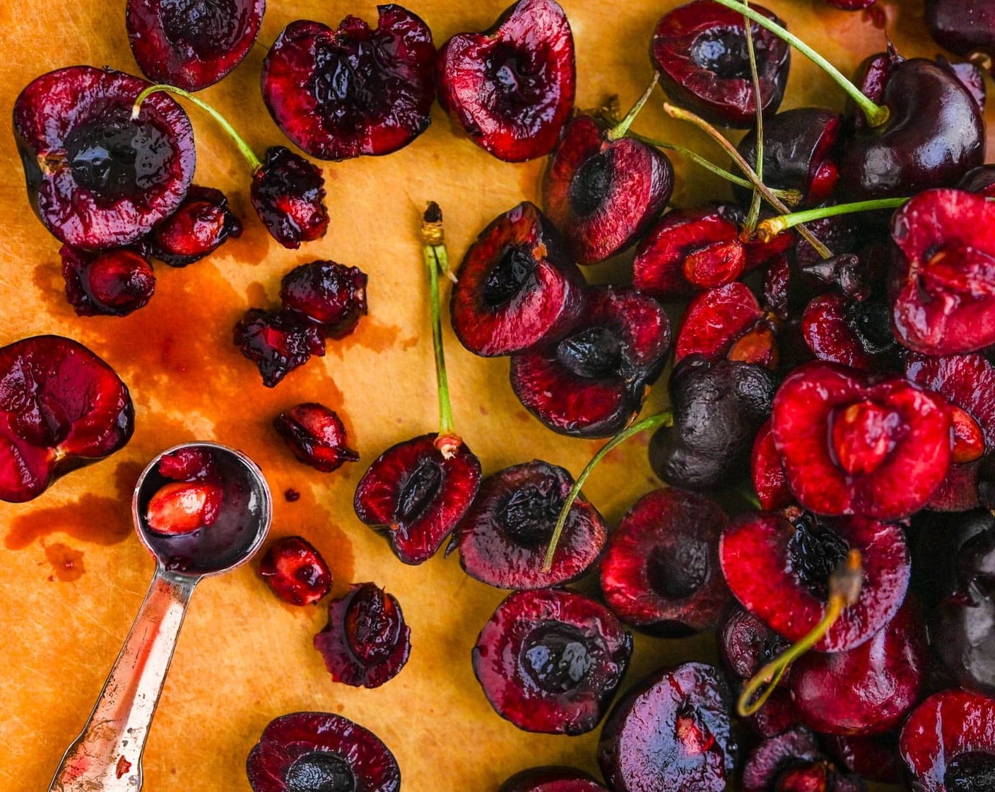 Schritt 2 Schwarze Herzkirschen (275 g) mit kaltem Wasser abspülen, Stiele entfernen und Kirschen halbieren und Kern entfernen.