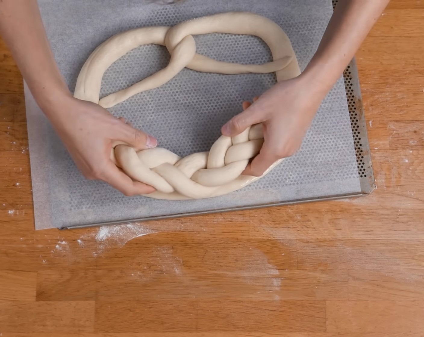 Schritt 20 Zum Schluss den Zopf auf die flach gedrückte Oberseite des Brezels legen und etwas andrücken.