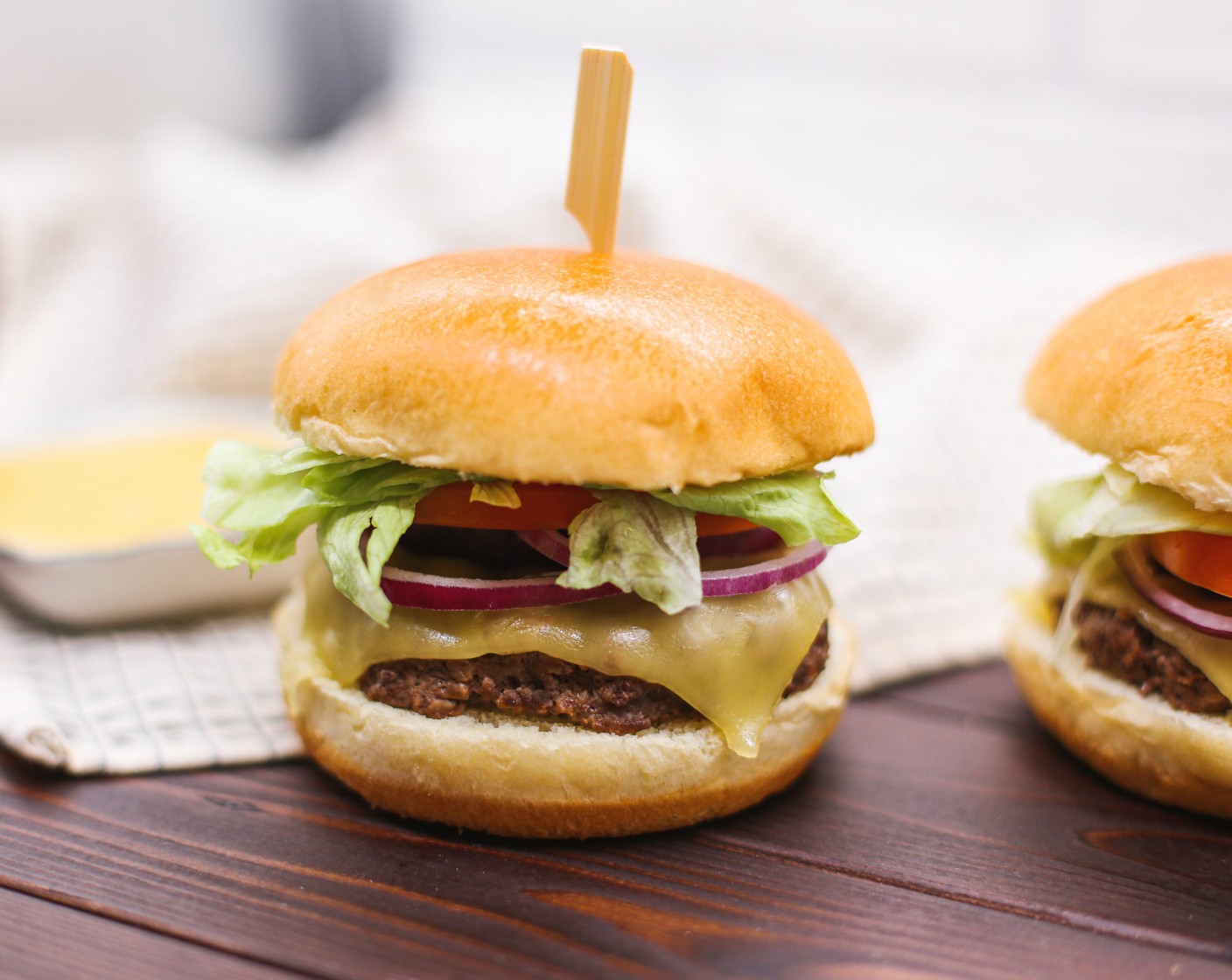 Schritt 6 Nun kann der Burger nach Belieben belegt werden. Eine gängige Variante ist, zuerst das untere Burger-Brötchen (2) dann die Sauce, das Fleisch mit dem Käse, Zwiebeln, Tomaten, Salat, nochmals die Sauce und zuletzt die obere Brötchenhälfte. Das kann aber je nach Belieben und Geschmack individuell gestaltet werden.