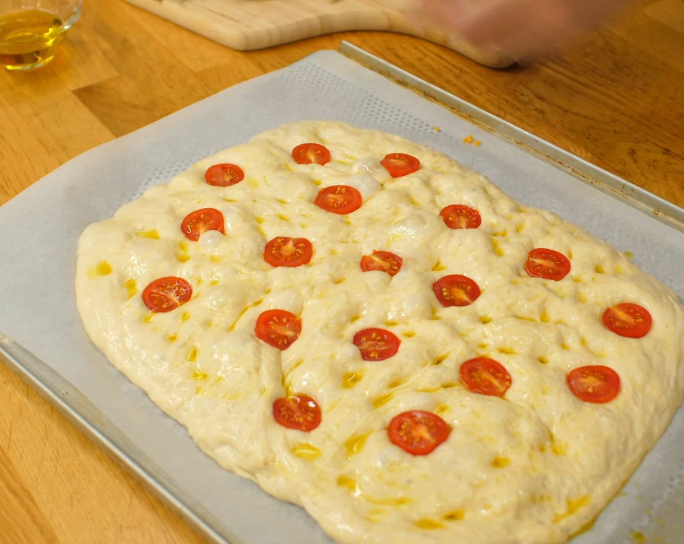 Schritt 9 Die Cherrytomaten (50 g) (oder Gemüse nach Wahl) halbieren oder in Stücke schneiden und den Teigling damit belegen und leicht in den Teig drücken.