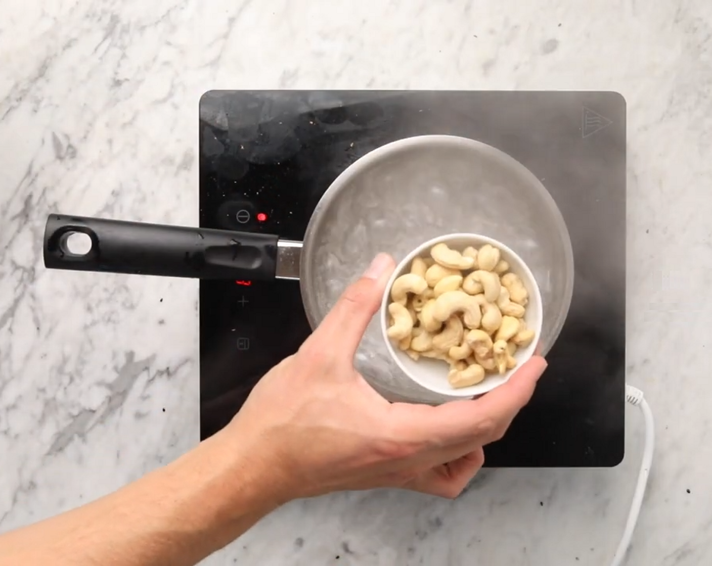 Schritt 2 Zur gleichen Zeit, in einem Topf mit kochendem Wasser die Cashews (80 g) für 10 Minuten garen.