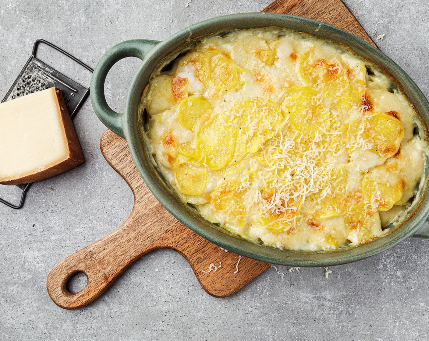 Schritt 6 Nach ungefähr 40 Minuten den Käse (100 g) gleichmässig über den Gratin reiben. Die Ofentemperatur auf 220 °C erhöhen und das Ganze für ca. 10 Minuten goldbraun überbacken.