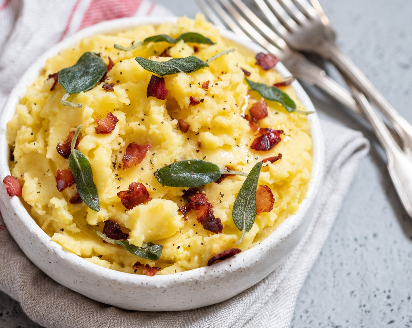 Schritt 5 Die gedämpften Kartoffeln in eine Schüssel geben und mit dem Kartoffelstampfer zerdrücken. Als nächstes Buttermilch (100 ml), Butter (1 EL), Speck, Zwiebeln und Gorgonzola untermischen. Das Ganze mit Salz (wenig) abschmecken und servieren.