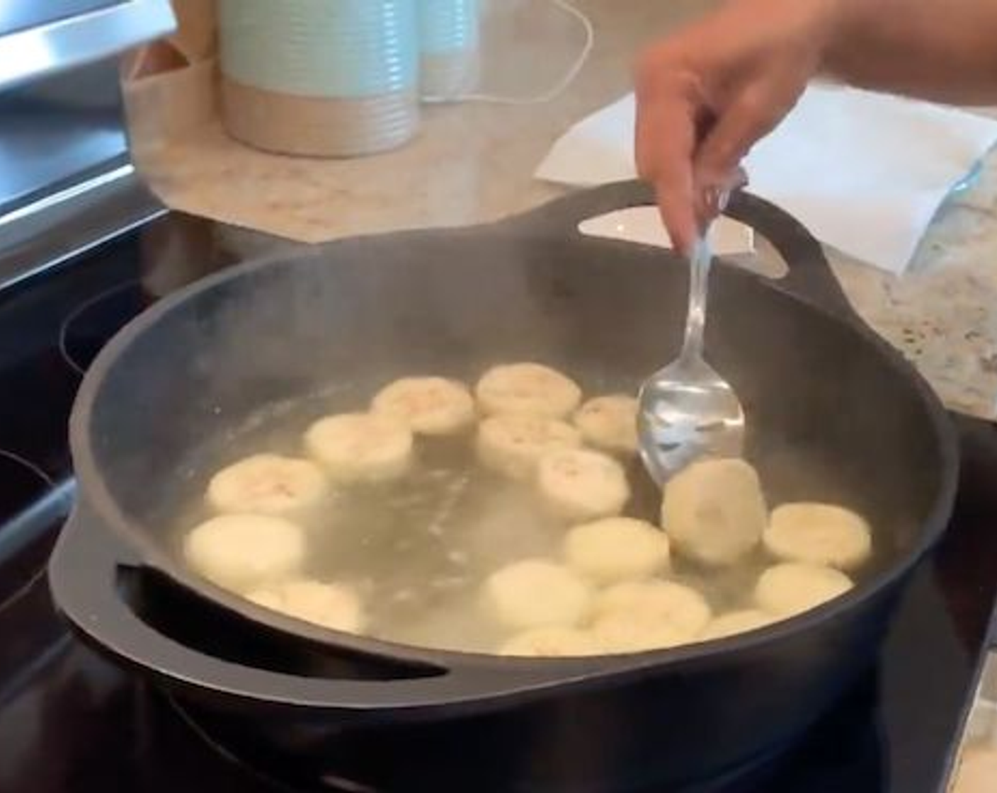 Schritt 3 Etwa 1 Zentimeter Wasser in eine Pfanne giessen und Salz (wenig) hinzugeben. Zum Kochen bringen und die Auberginenscheiben hineinlegen. Etwa 5 Minuten auf jeder Seite kochen. Zum Abtropfen auf ein Papiertuch legen.