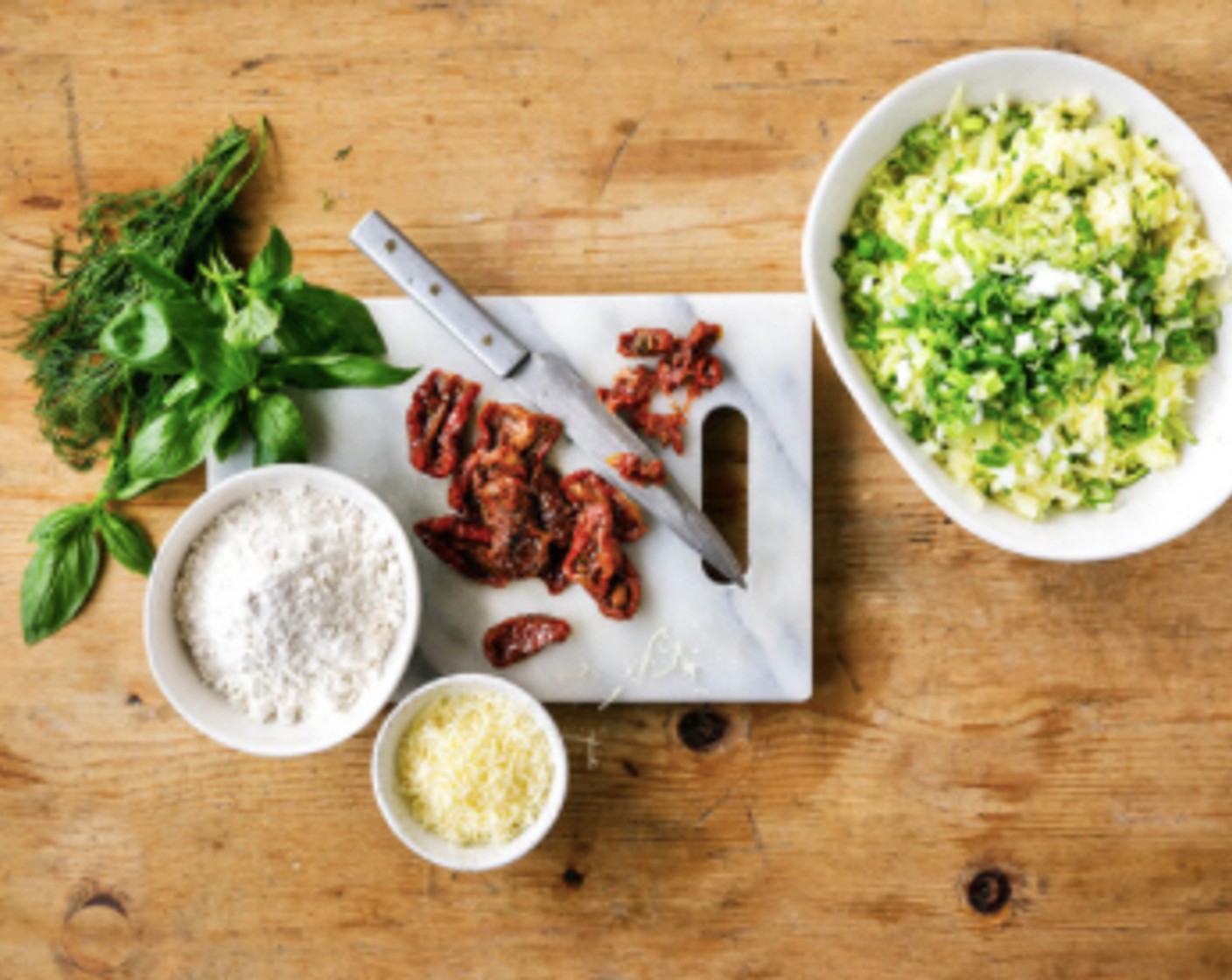 Schritt 3 Die Tomaten (100 g) die Frühlingszwiebel (1) sowie den Dill (1/2 Bd.) und den Basilikum (1/2 Bd.) grob hacken. Mit den Eiern (5), dem Mehl (280 g), dem Backpulver (1 TL) und dem Käse (80 g) zu den Kartoffeln geben, alles vermengen. Mit Salz (1 TL) und Pfeffer (wenig) würzen. Die Masse in die vorbereitete Kuchenform geben, mit einem Löffel glatt streichen.