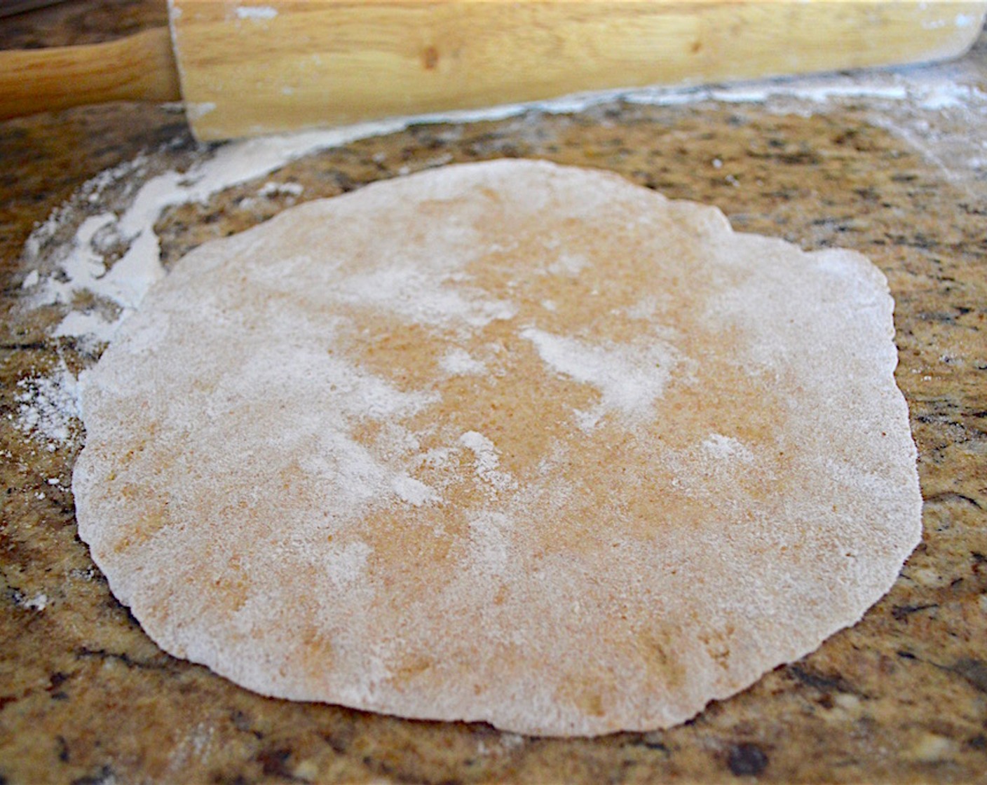 Schritt 5 Teig flach ausrollen oder flach drücken und in Portionen teilen. Jede Portion zu einer Kugel rollen, die etwas grösser als ein Golfball ist. Dann auf einer bemehlten Fläche zu einer flachen, dünnen Scheibe ausrollen. So lange wiederholen, bis der Teig aufgebraucht ist. Es sollte für etwa 20 Pita reichen.