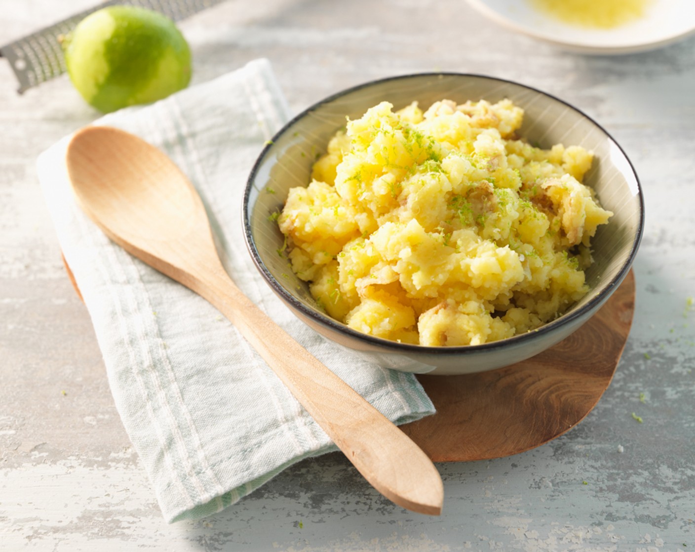 Schritt 4 Nach dem Garen, die gedämpften Kartoffeln in eine Schüssel geben und mit dem Kartoffelstampfer zerdrücken. Als nächstes die Butter (3 1/3 Esslöffel) schmelzen, die Schale der Limette (1/4) abreiben und den Saft auspressen. Alle Zutaten untermischen. Zum Schluss den Kartoffelbrei mit dem Limettensaft und dem Salz (wenig) nach Belieben abschmecken.