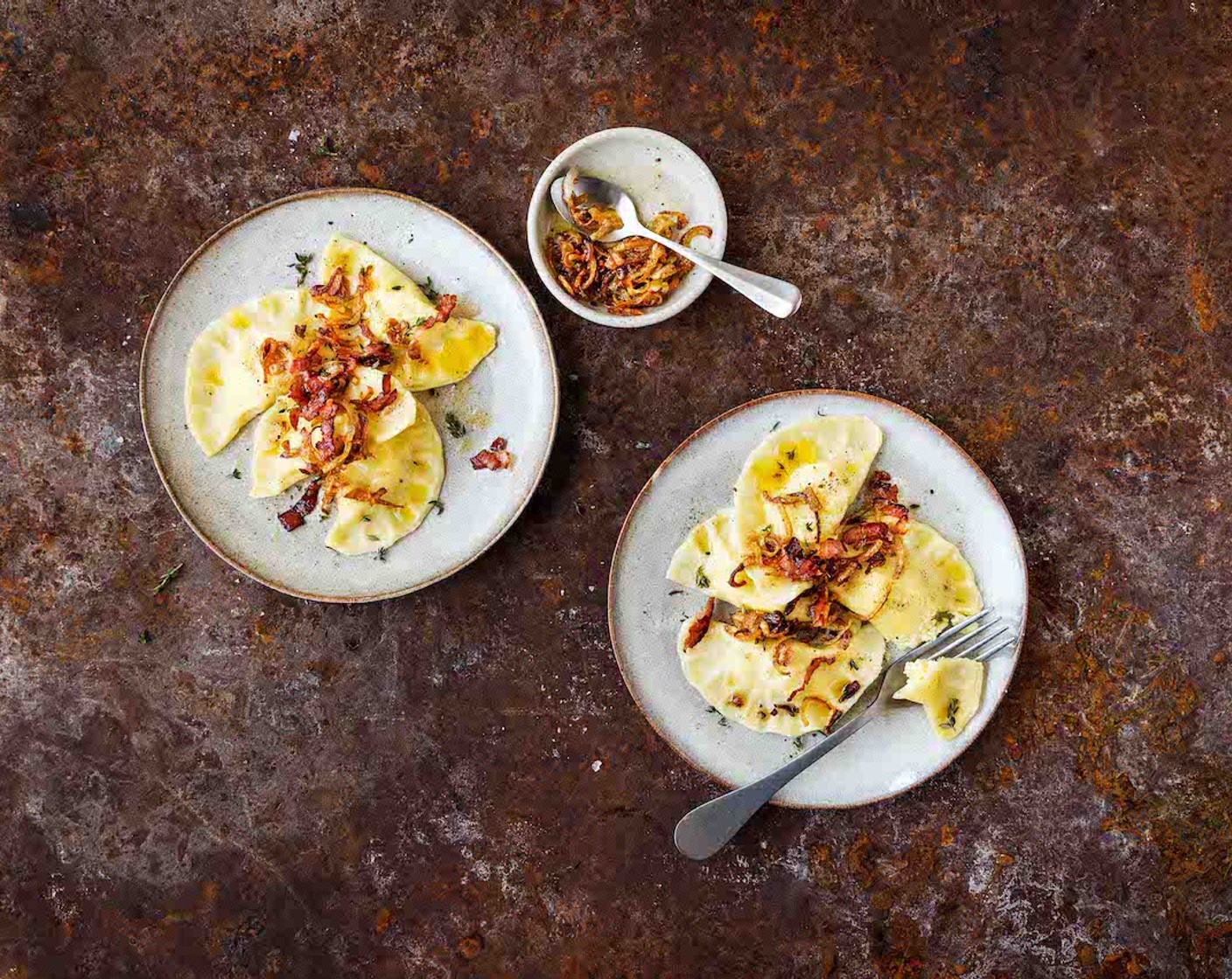 Schritt 6 Den Speck (4 Scheiben) in feine Streifen schneiden. In eine Bratpfanne geben und ohne Fett erhitzen, knusprig braten und aus der Pfanne nehmen. In derselben Pfanne die Butter (3 Esslöffel) schmelzen. Die Zwiebelstreifen (1) zugeben und bei mittlerer Hitze anschwitzen. Den Speck zugeben und die Piroggen vor dem Servieren in der aromatisierten Butter schwenken.