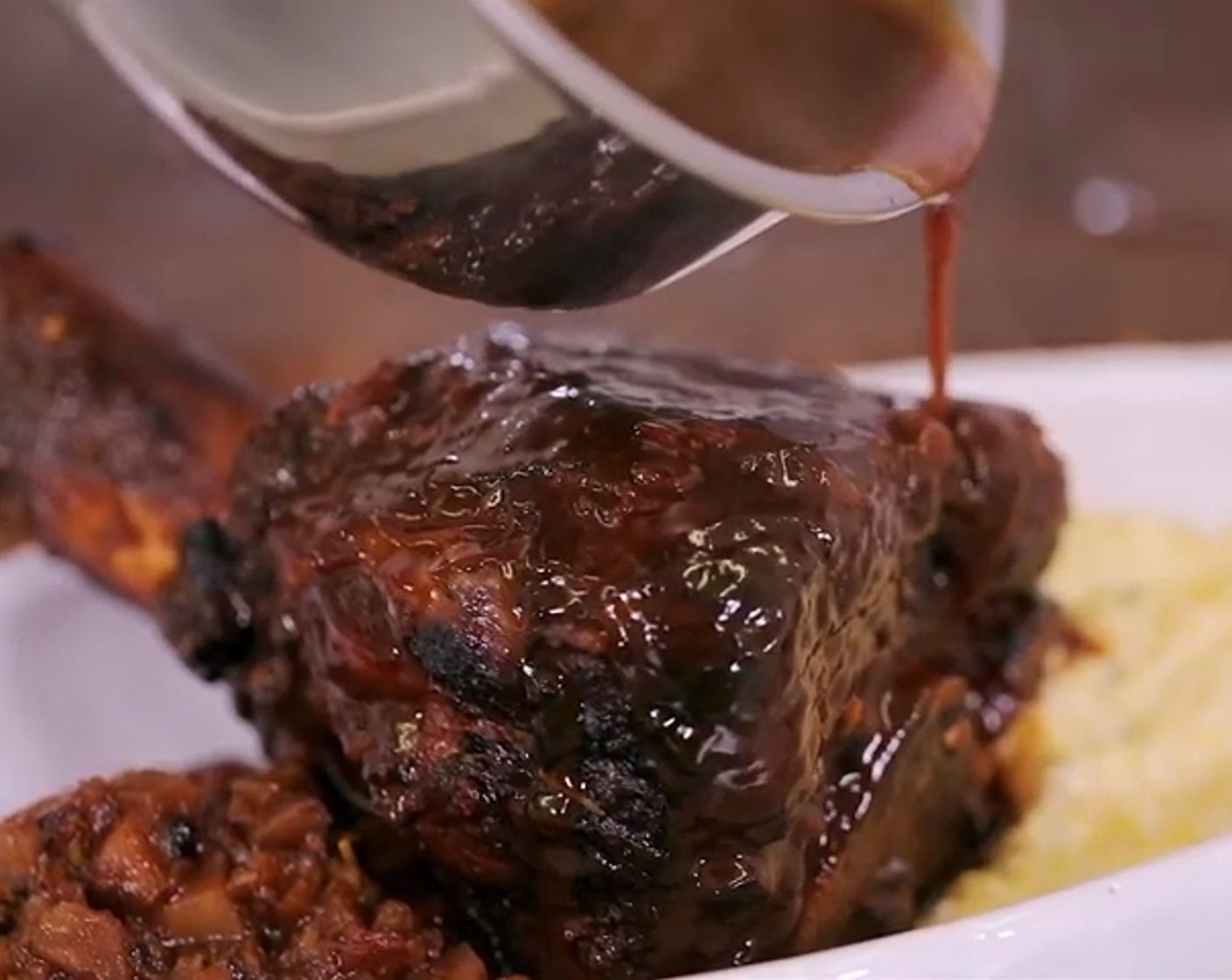 Schritt 7 Nach der Garzeit die Porzellanform aus dem Ofen nehmen, Kalbshaxe aus dem Sud nehmen und warm stellen. Das Gemüse absieben und zum Fleisch geben. Den Sud in eine Pfanne geben, sirupartig einkochen lassen und zum Schluss über die Kalbshaxe geben.
