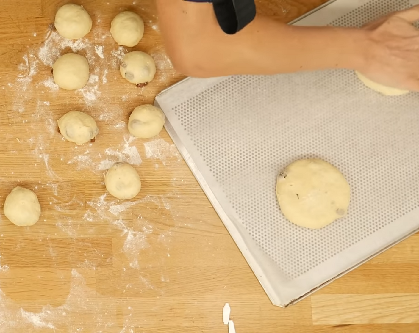 Schritt 9 Das Mittelstücke und zu einer Kugel formen und auf ein mit Backpapier belegtes Blech legen, dann mit der Hand leicht flach drücken.