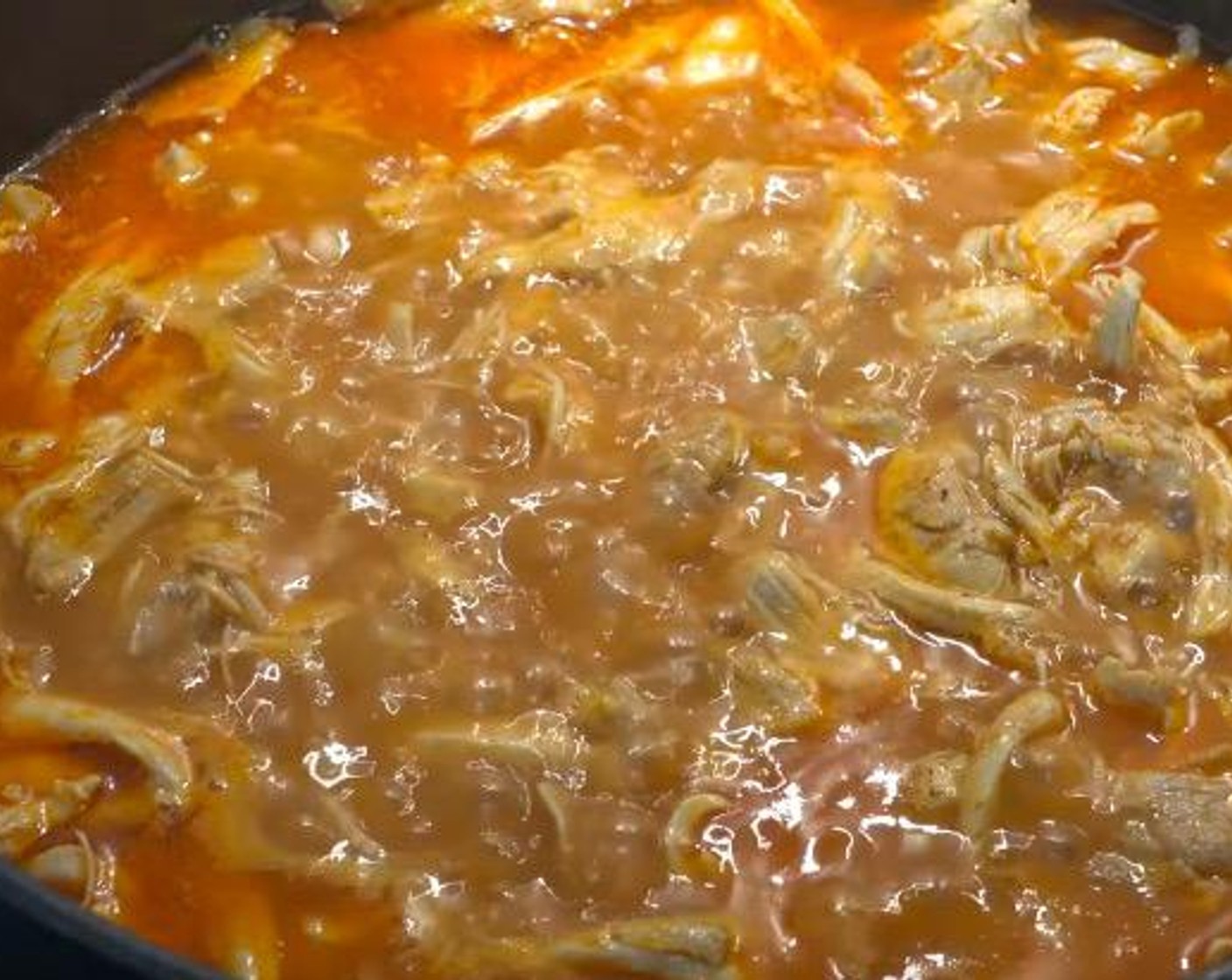 Schritt 4 Das zerupfte Poulet zurück in die Pfanne geben und für weitere 5-10 Minuten köcheln lassen, bis die Sauce andickt.