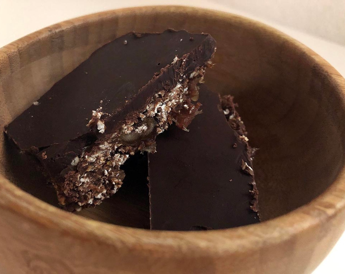 Schritt 5 Abschliessend das Backpapier zusammen mit der Riegelmasse aus der Auflaufform heben und Vierecke nach gewünschter Grösse schneiden. Die Riegel direkt geniessen oder im Kühlschrank verschlossen aufbewahren.