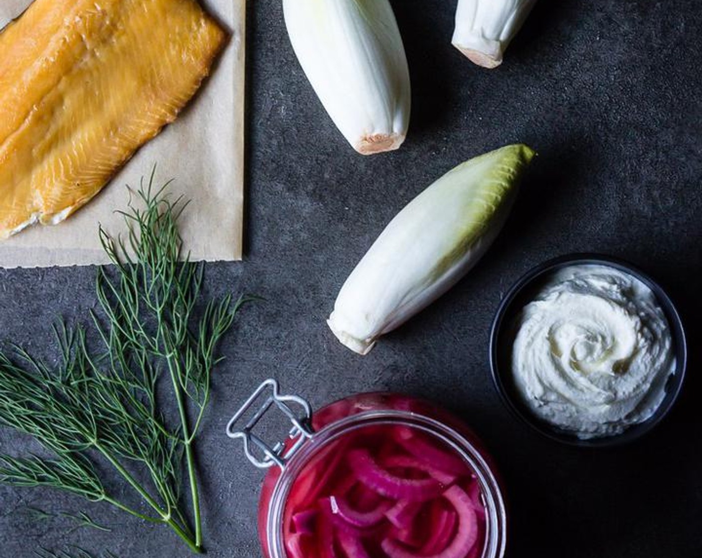 Schritt 6 Die untere Hälfte jeder Endivien (3) mit etwa 1 1/2 Teelöffel geschlagenem Ziegenkäse füllen und jeweils ein kleines Stück Rauchforellen (115 g) auf den Ziegenkäse legen.