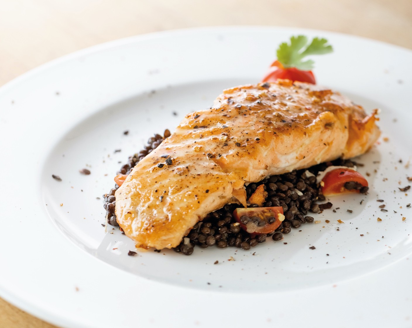 Schritt 9 Den Linsensalat auf dem Teller anrichten, den Lachs darauf setzen und die Honigbutter auf dem Fisch verteilen.