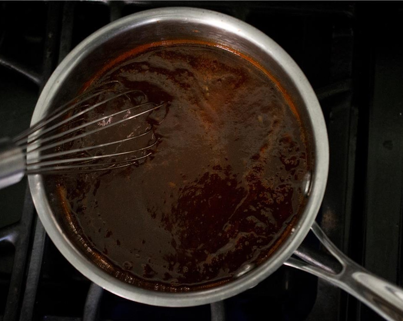 Schritt 3 Die vorbereiteten Zutaten nacheinander in die Pfanne geben. Die Hitze auf niedrige Stufe reduzieren und das Ganze für 20 Minuten simmern lassen, dabei gelegentlich umrühren, bis die Sauce eingedickt ist. Dabei darauf achten, dass die Sauce nicht kocht.