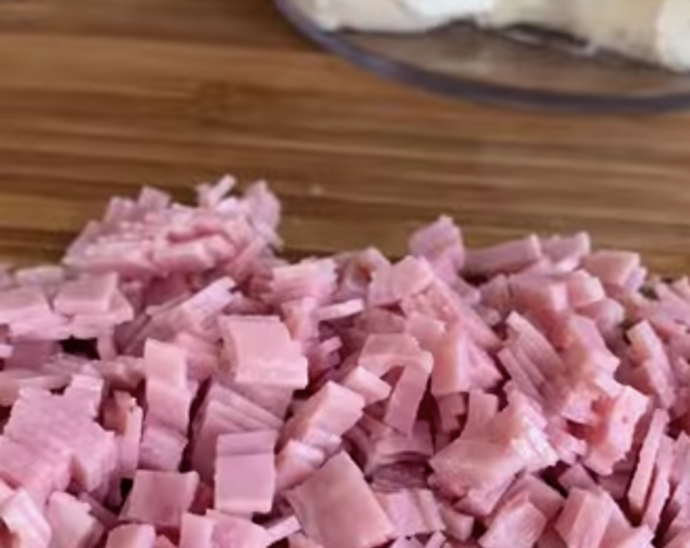 Schritt 2 Mozzarella (8) und Kochschinken (2 Scheiben) in feine Stücke schneiden. Beides zusammen mit dem Frischkäse (100 g) in einer Schüssel vermengen. Mit Glarner Gewürz (wenig), Kräuter-Mix (2 Esslöffel), Salz (wenig) und Pfeffer (wenig) abschmecken.