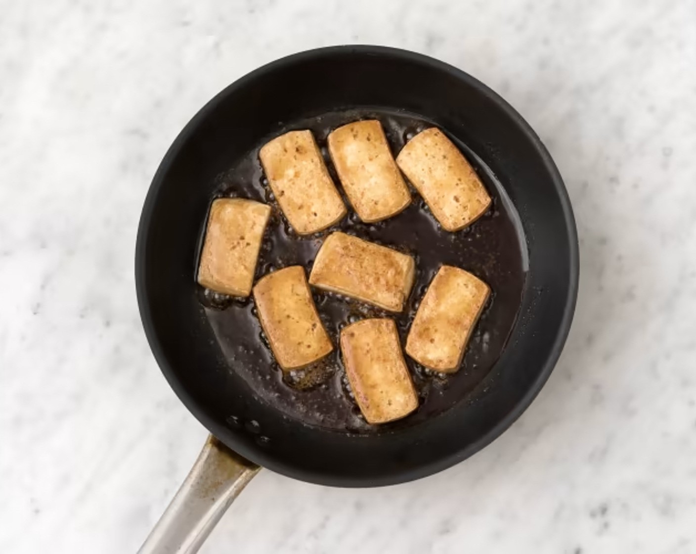 Schritt 4 Tofu (500 g) in 16 Scheiben schneiden (bei 4 Portionen) und in einer kleinen Schüssel mit dem Cajun Gewürz (2 Teelöffel) und Öl (1 EL) marinieren. Eine grosse Bratpfanne ohne Zugabe von Fett auf mittlerer Stufe erwärmen und Tofuscheiben 2–3 Minuten je Seite anbraten. Anschliessend Tofuscheiben aus der Bratpfanne nehmen und warm halten.