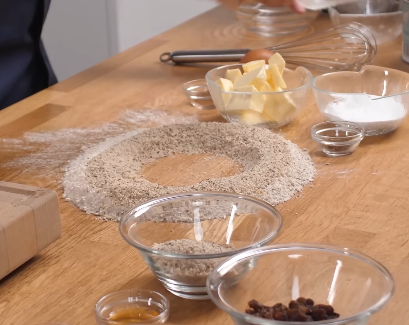 Schritt 1 Für den Teig, Mehl (150 g) mit den Haselnüssen (150 g) auf eine Arbeitsfläche geben und in der Mitte eine Mulde formen.