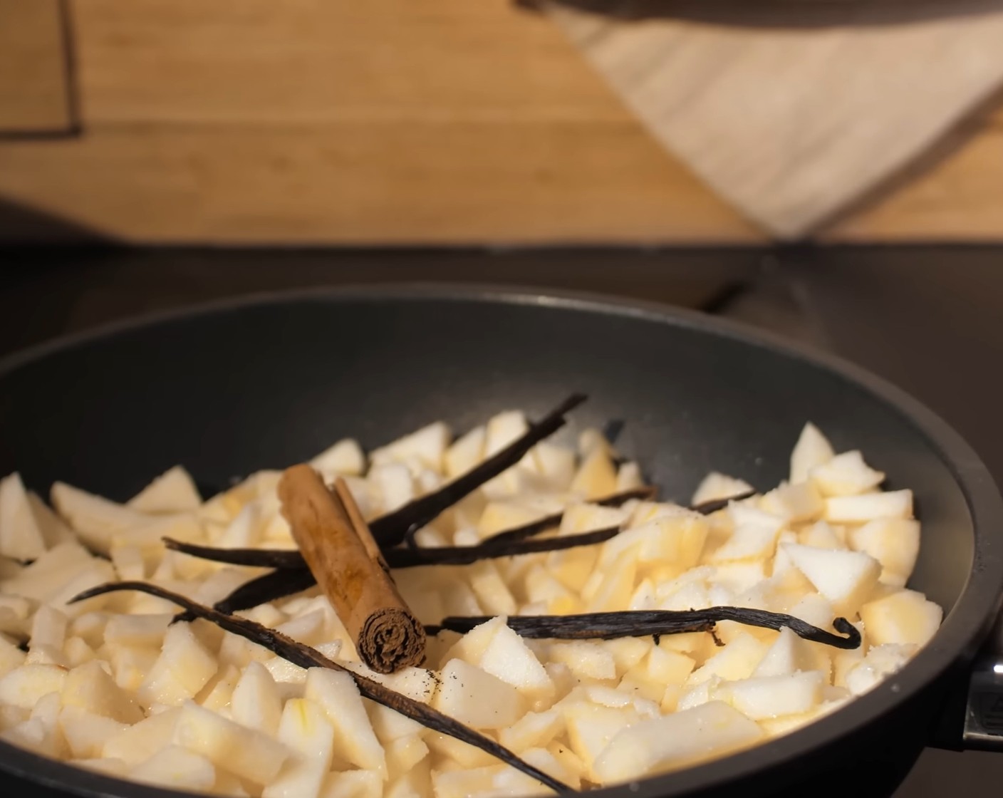 Schritt 5 Anschliessend die Apfelstücke mit dem Zucker (4 Esslöffel), Saft der Zitrone (1), Vanilleschoten (2) und Zimtstange (1) in einen Kochtopf geben und auf dem Herd etwa 5–10 Minuten köcheln lassen.