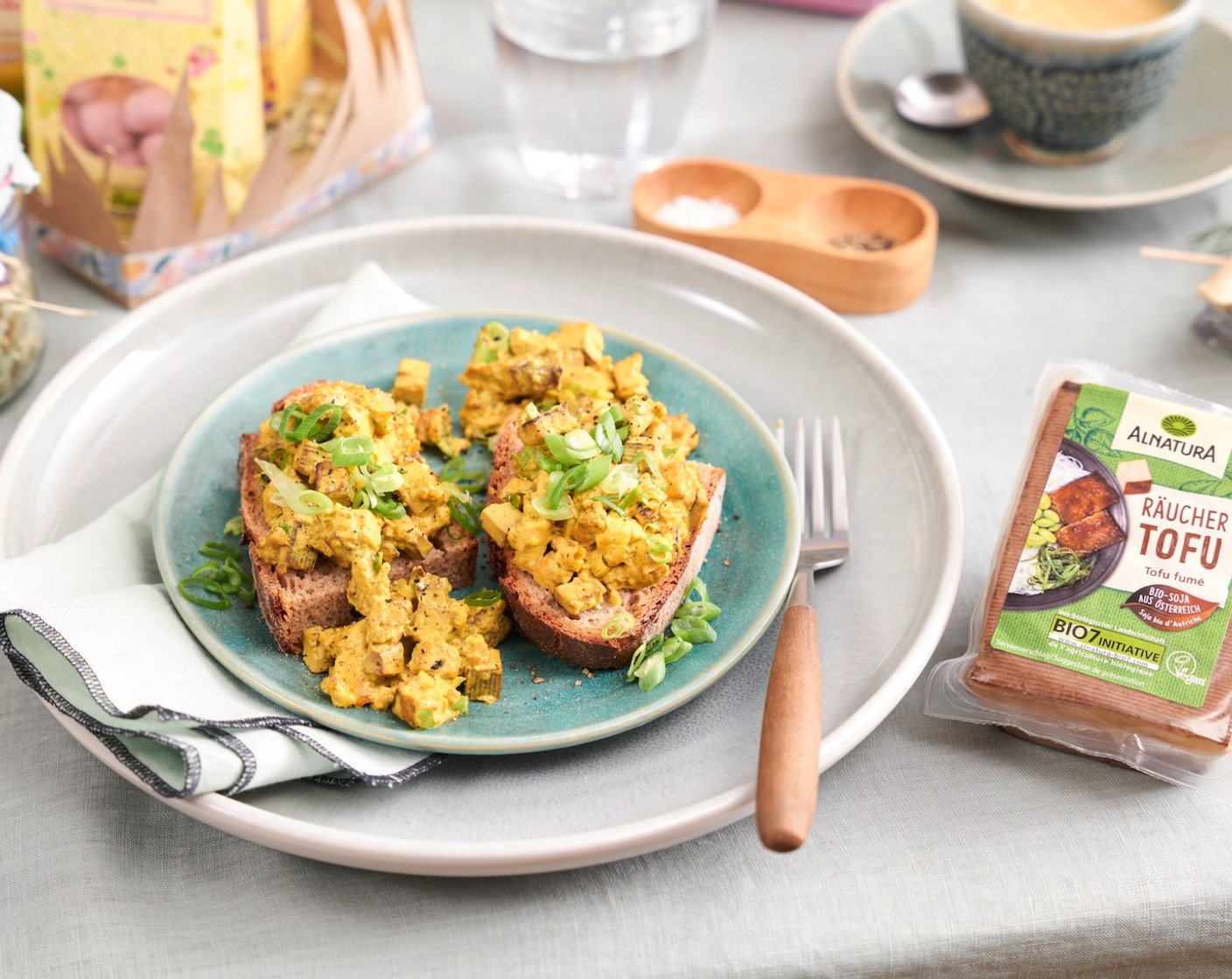Schritt 2 Rapsöl (3 Esslöffel) in einer beschichteten Pfanne erhitzen und Tofu bei hoher Hitze anbraten, dabei mehrmals wenden. Tofu mit der Shoyu Sauce (2 Esslöffel) ablöschen, Hitze etwas reduzieren und Kurkuma (1 TL) und Kala Namak Salz (2 Teelöffel) zugeben, dabei mehrmals wenden. Frühlingszwiebeln mit in die Pfanne geben und kurz mitbraten. Abschliessend die Sojasahne (200 ml) zugeben und ca. 4 Minuten einkochen. Mit Pfeffer (1/2 TL) abschmecken und mit restlichem Grün der Frühlingszwiebeln garnieren.