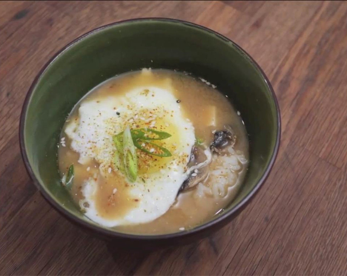 Schritt 5 Ei (1) in einer heissen Pfanne braten und zusammen mit Reis (85 g) und Miso in einer Schüssel servieren. Mit Chilipulver (wenig) würzen und mit grünen Bundzwiebeln und Sesam (wenig) garnieren.